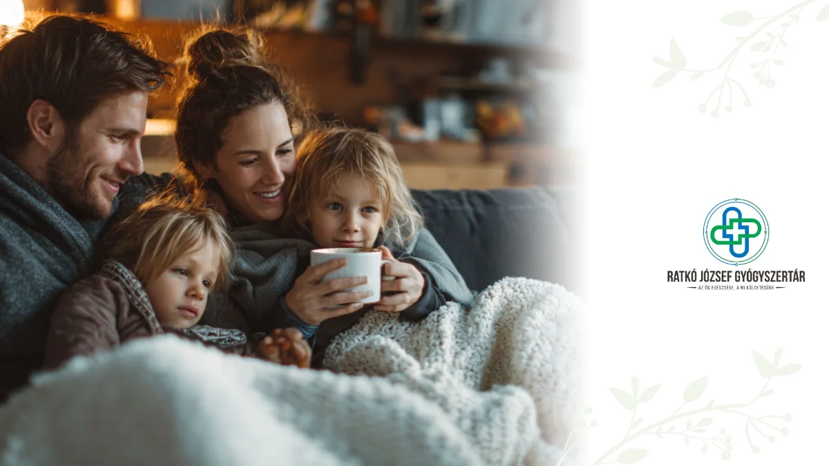 apa, anya, gyerek a kanapén egynmáshoz bújva takaró alatt, meleg teával, jobb oldalon ratkó józsef gyógyszertár logója
